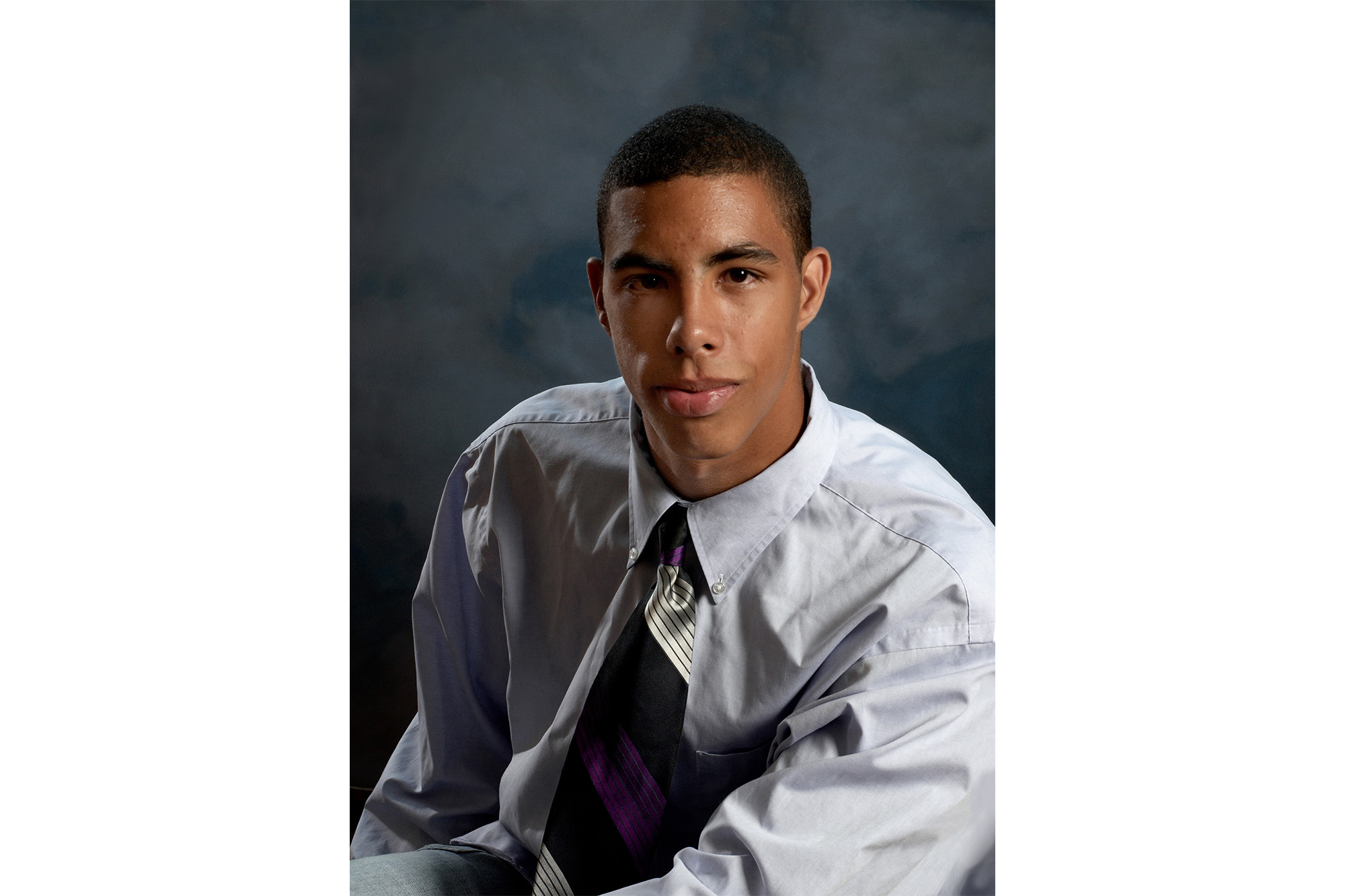 A young man looks straight into the camera in this candid studio portrait.